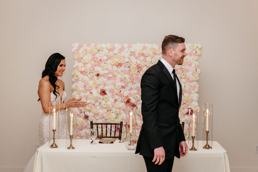 a couple in front of a flower wall in a blank canvas wedding venue near reading PA